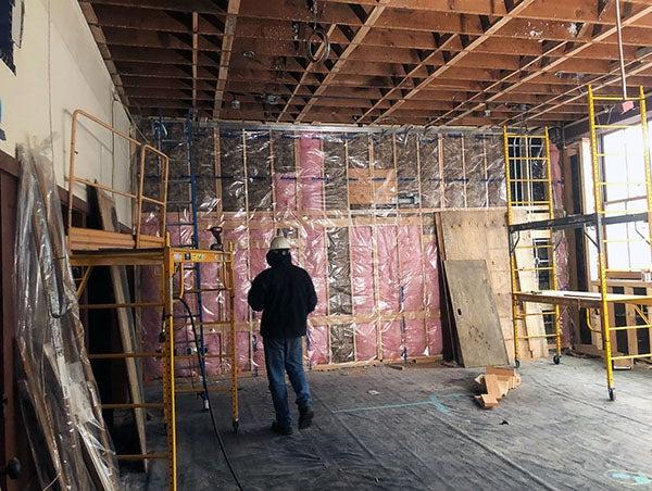 木框架墙和天花板在透明塑料后面有粉红色的绝缘材料